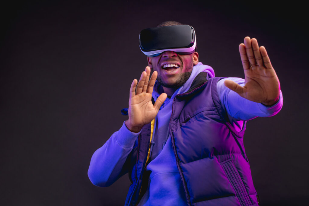 Man wearing virtual reality goggles isolated on dark purple background